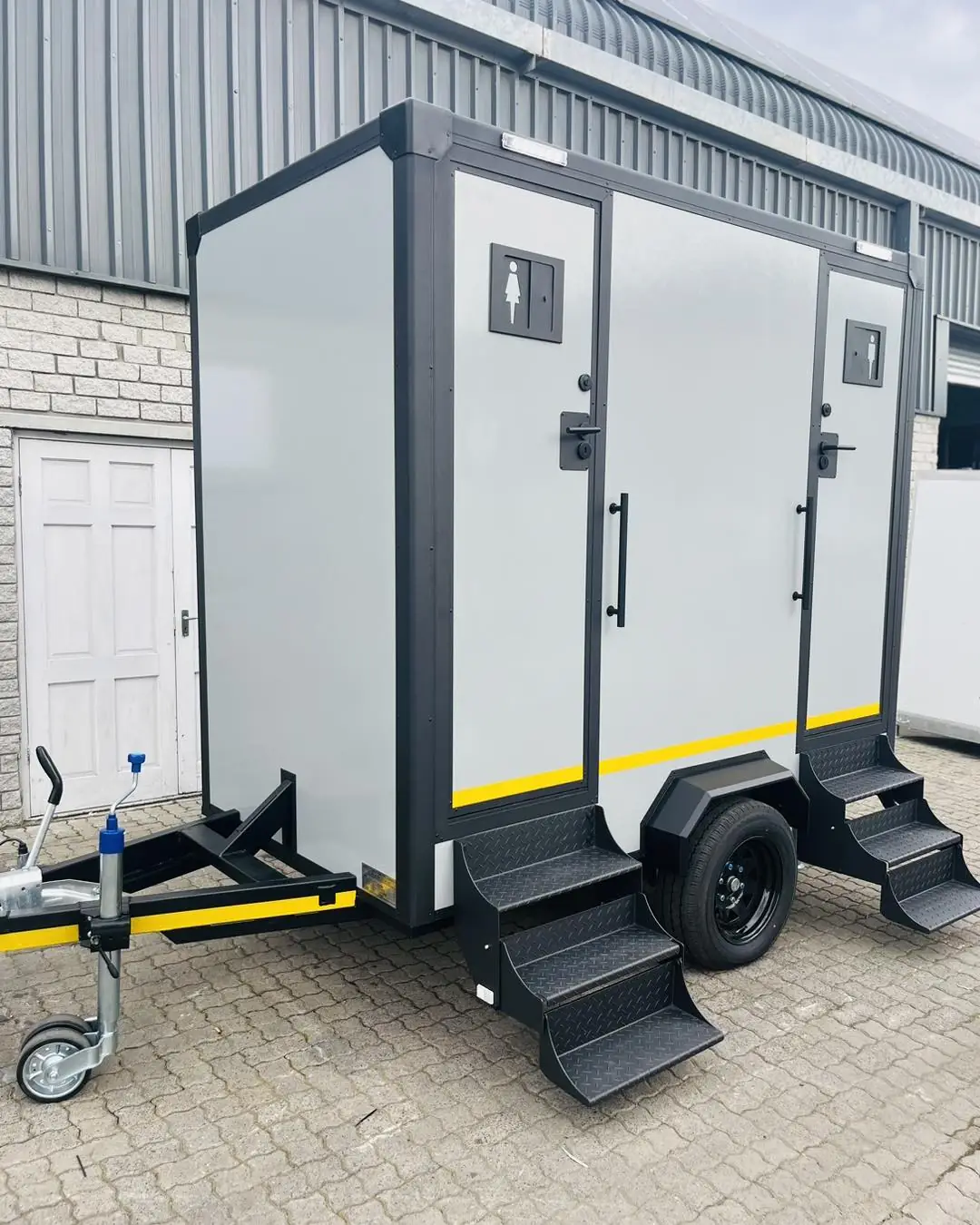 Restroom trailer with two separate doors and fold-down steps